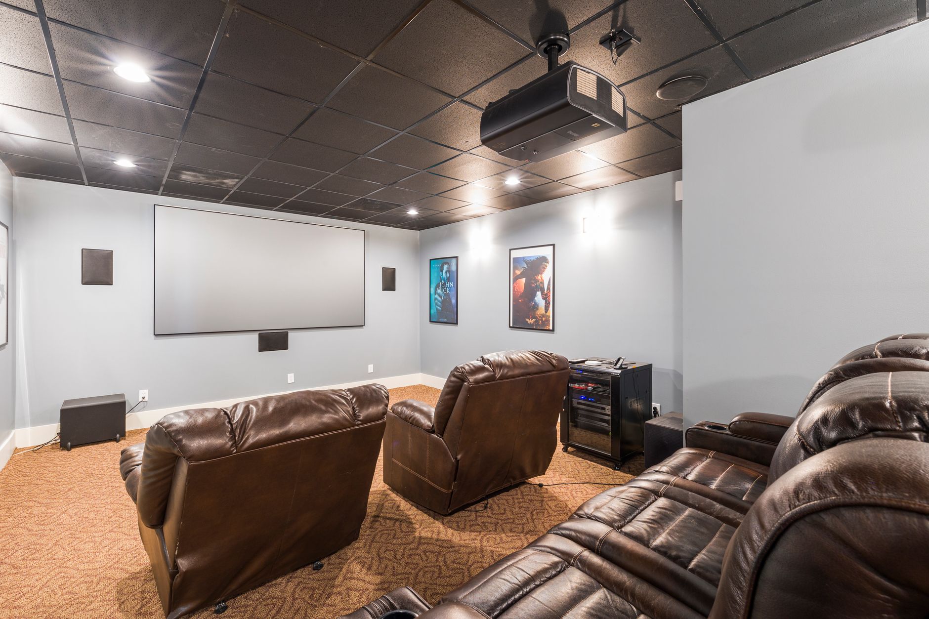 Luxury home theater media room with large screen and recliner seating